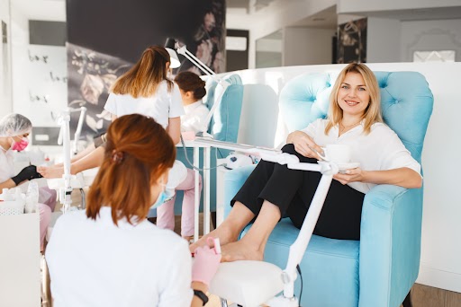 A woman receiving a pedicure at a nail bar, with her feet being washed in a tub.