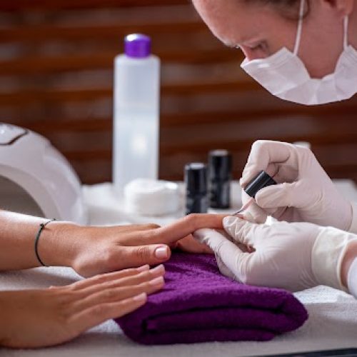 A woman receiving a manicure at a nail salon.